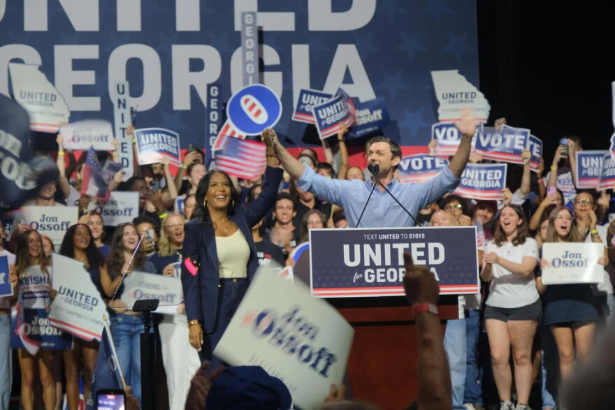 Sen. Jon Ossoff and former Atlanta Mayor Keisha Lance Bottoms take the stage together at the Georgia Theater. Behind them a crowd of young voters cheer with signs that say United for Georgia.