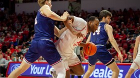 Illinois State basketball player Chase Walker dribbles between two defenders in a game at CEFCU Arena