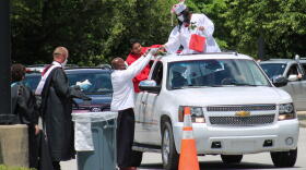 Graduating students and staff wear protective masks during the ceremony. Teachers from Emmerich Manuel High School handed out diplomas and gifts during the drive-thru ceremony on May 30.