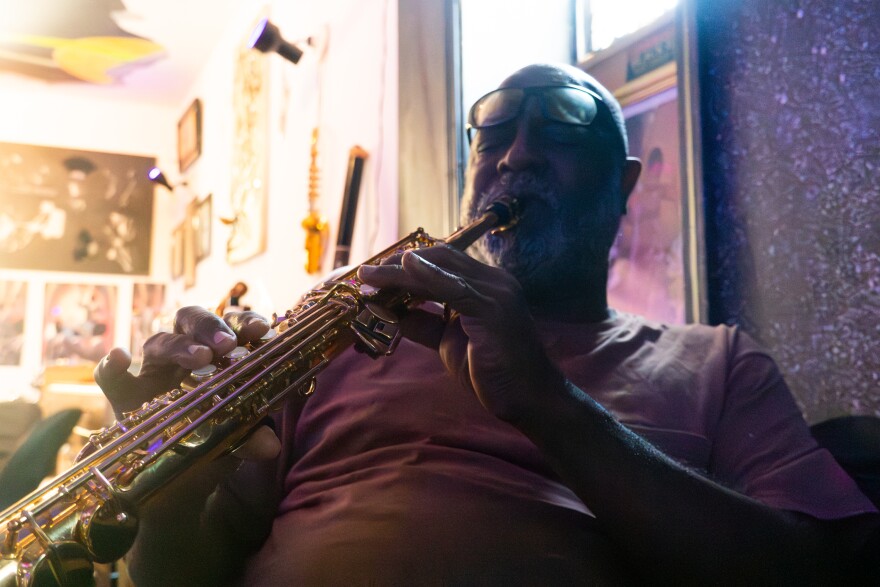 Rahtu Stroud plays a saxophone in the first-floor performance space of the home he shares with his wife, Emma Stroud, on Wednesday, Sept. 10, 2025. The couple hosts small community music gatherings there, but they say storm damage worsened for weeks after the tornado as they struggled to secure roof repairs through their insurance provider.