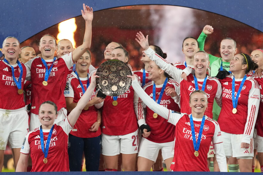 FILE - Arsenal's team captains Kin Little, left, and Leah Williamson, right, lift the trophy after winning the Women's Champions Cup final soccer match between Arsenal FC and SC Corinthians in London, Sunday, Feb. 1, 2026.