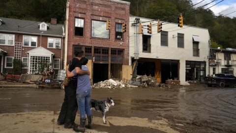 Resident Anne Schneider, right, hugs her friend Eddy Sampson as they survey damage caused by Hurricane Helene, Oct. 1, 2024, in Marshall, N.C.