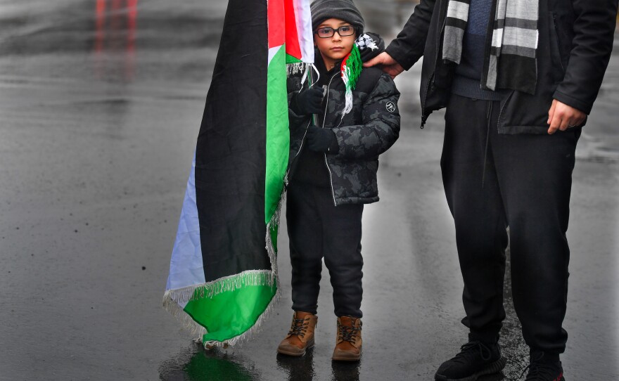 A boy holds the Palestinian flag upon arriving to the Free Palestine Rally in Scranton.