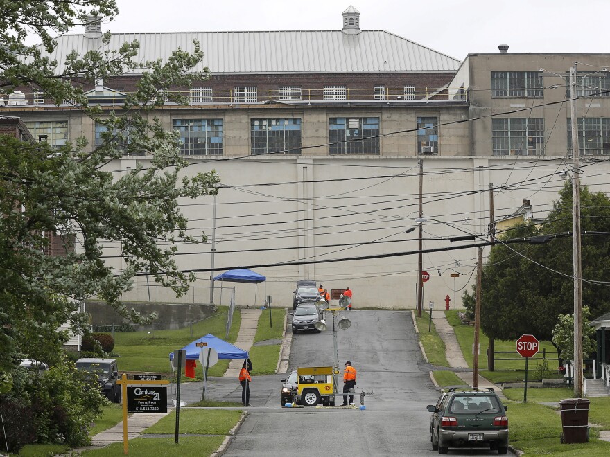 Corrects officers stand near a manhole where two convicted murderers are believed to have emerged after escaping from Clinton Correctional Facility.