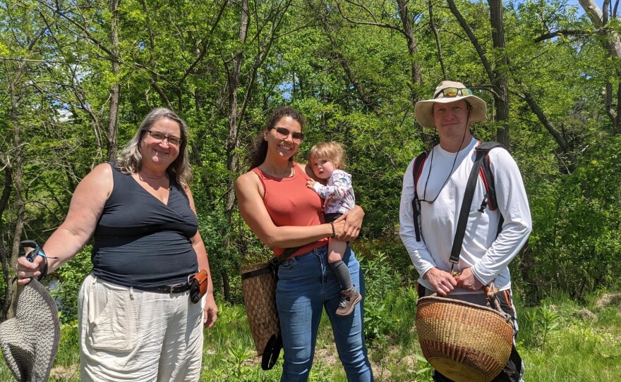 Christine, Melinda and Jimmy pose for a photo in front of trees in a parking lot