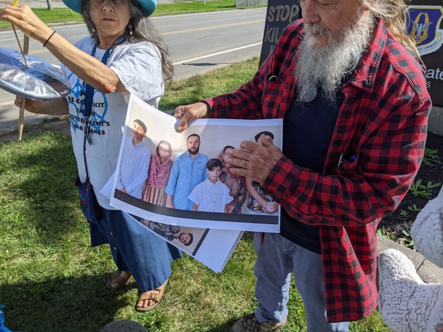 Two peace activists hold a picture of the family killed in Afghanistan.