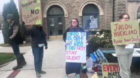 Several people holding hand made signs with messages including "I need to be able to tell my kids I did not stay silent" and "Jason Buckland please don't sell" and "Preserve Monroe no data center."
