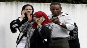 People wait outside a mosque in central Christchurch, New Zealand, Friday, March 15, 2019.