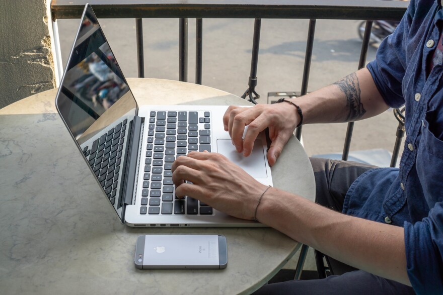 man using laptop and cell phone