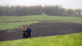 Two men walk the scene of a natural gas transmission line explosion in western Pennsylvania, April 29, 2016. The blast was so powerful it ripped a 12-foot crater into the landscape and burned a section of the field with a quarter-mile radius. 