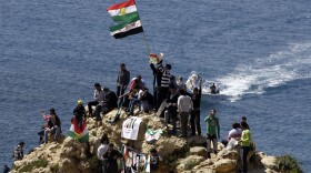 Kurds hold up Syria's pre-Baath and Kurdish flags, chanting slogans against the Syrian regime as they celebrate Noruz spring festival in the lebanese capital Beirut on March 21, 2012. 