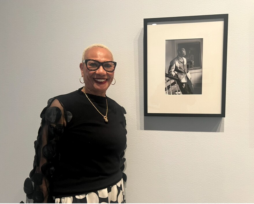 Ella Parks, the great niece of Gordon Parks, stands in front of a photo of Muhammad Ali.