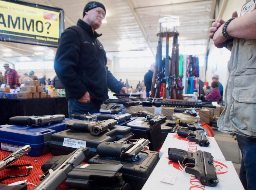 Gun show promoter Ramon Amoureux, right, talks to a customer at a gun show in Caldwell, Idaho. Amoureux, like many in the gun business, has noticed his sales wane with the pro-gun presidency of Donald Trump. Under President Trump, gun owners are less afraid of new restrictions and less apt to stockpile. 