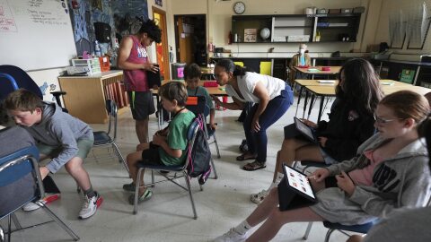Art teacher Lindsay Johnson, center, has students explore how to use generative AI features in Canva at Roosevelt Middle School, Wednesday, June 25, 2025, in River Forest, Ill. (AP Photo/Nam Y. Huh)