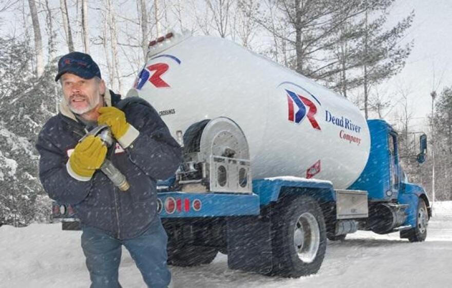 A worker with Maine-based Dead River pumps heating oil from a truck in winter.