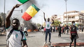 Protesters wave the Senegalese national flag during a protest in Dakar, Senegal after the country's opposition leader Ousmane Sonko was charged with rape. 