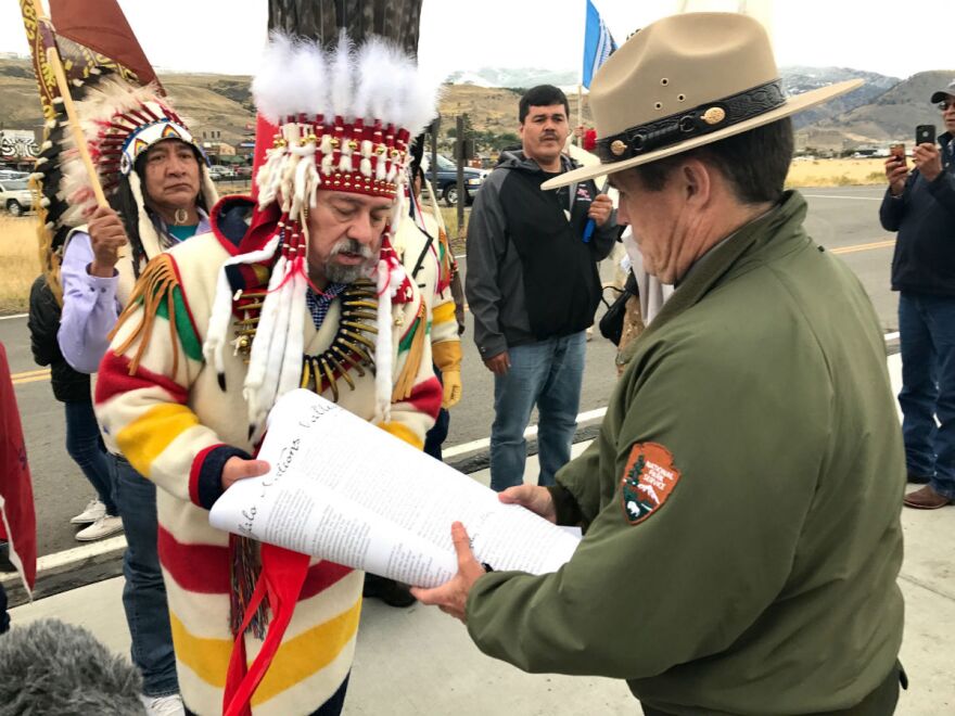 Piikani Nations Chief Stanley Charles Grier hands over a signed declaration to Yellowstone National Park deputy superintendent Pat Kenny on Saturday.