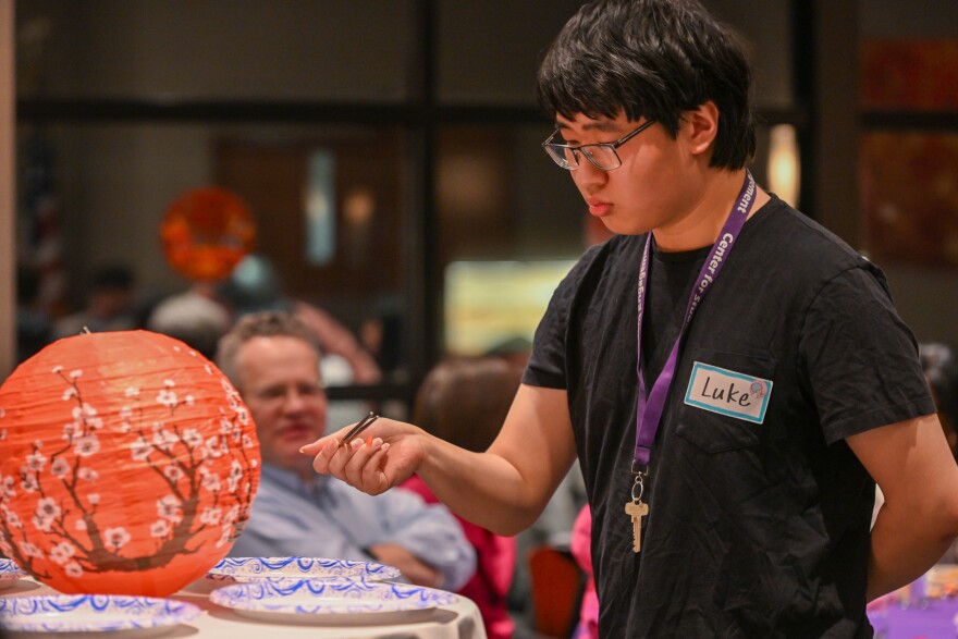 A student at the University of Scranton participates in a chopstick competition during the university's Lunar New Year celebration.
