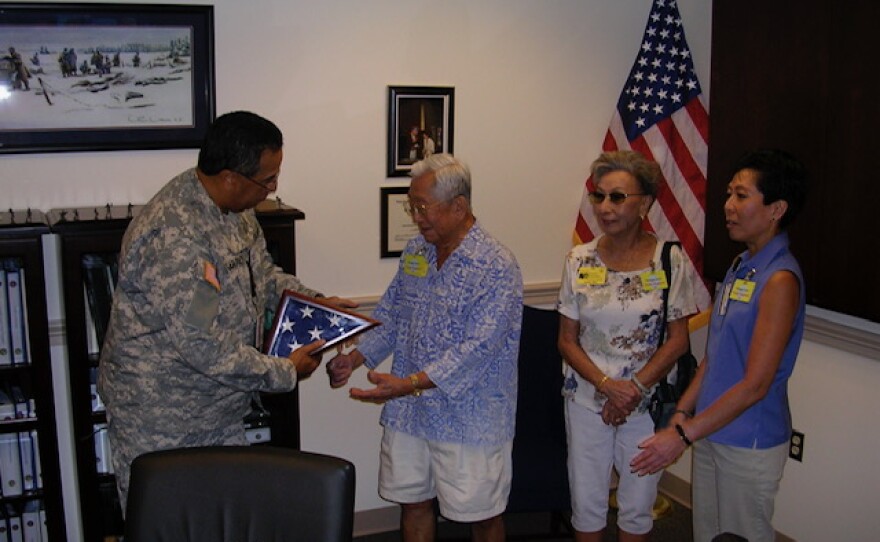 Walter Heirakuji (middle) with wife, Sally, and daughter, Lynn, at the Pentagon in 2007 being presented with a U.S. flag for his service during World War II.