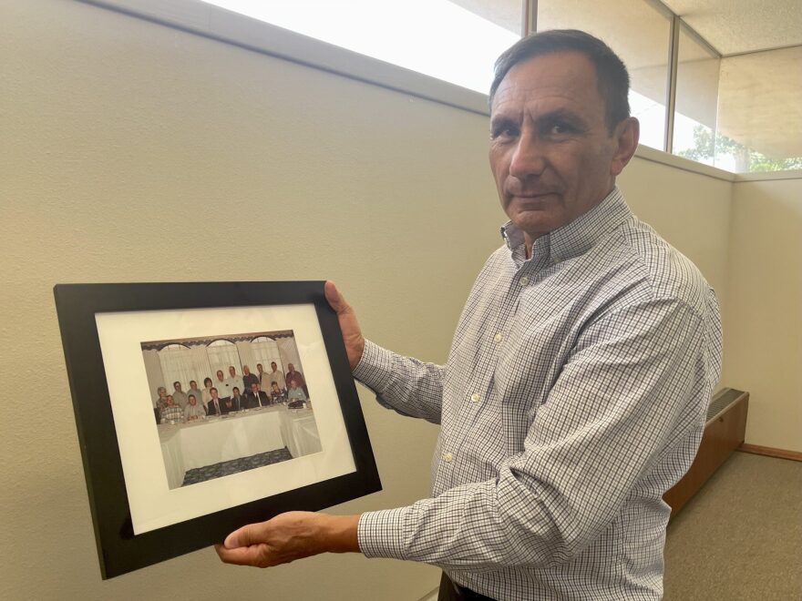 Orlando Ortega with a photo of the group of people initially involved in the 1990s push to build the pipeline.