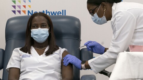Sandra Lindsay (left) a nurse at Long Island Jewish Medical Center, is inoculated with the Pfizer-BioNTech COVID-19 vaccine by Dr. Michelle Chester on Monday in New York.
