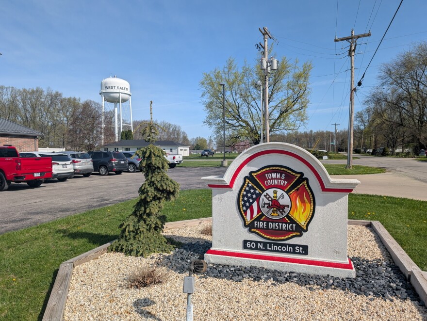 To the right is the sign for the Town and Country Fire District. In the background is a water tower that says West Salem. 