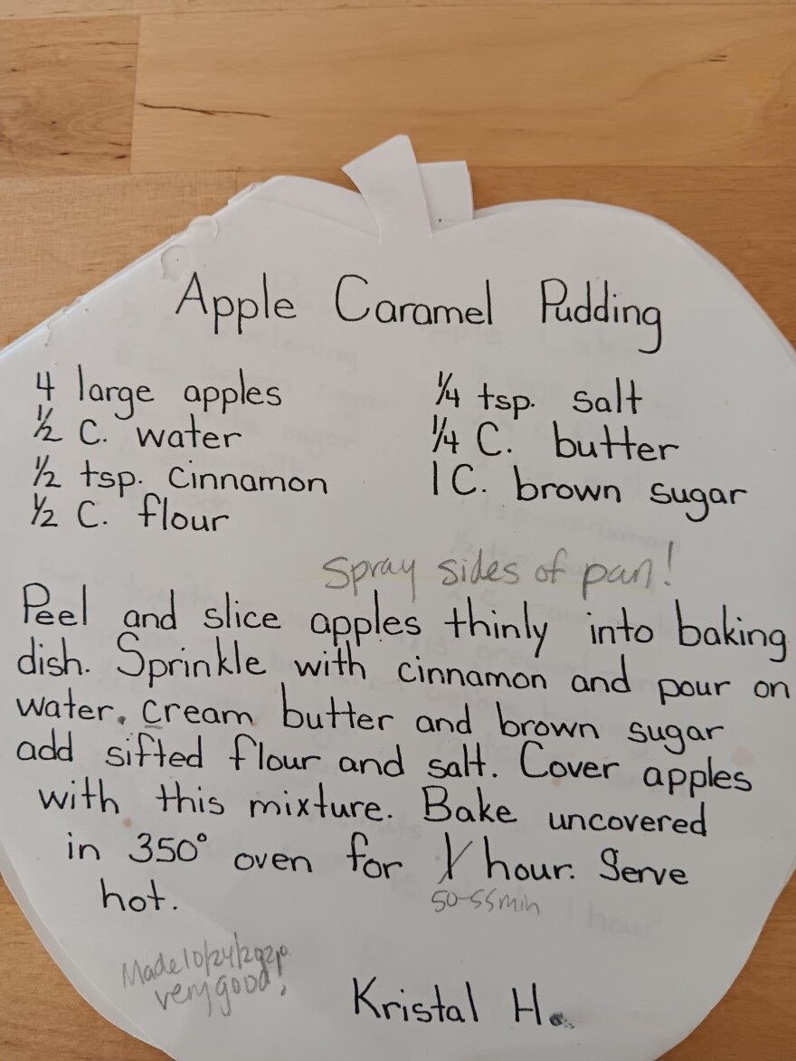 A recipe for apple caramel pudding handwritten on an apple-shaped piece of paper.
