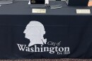 a black banner with a white silhouette of former President George Washington and an inscription that reads City of Washington Est. 1825