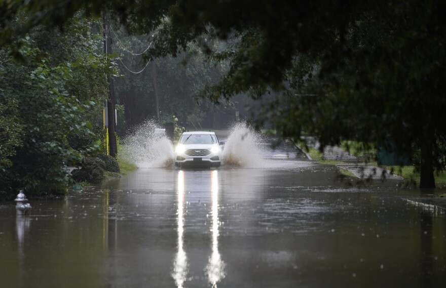 A car attempts to drive through flood waters near Peachtree Creek near Atlanta, as Tropical Storm Fred makes its way through north and central Georgia on Tuesday, Aug. 17, 2021.