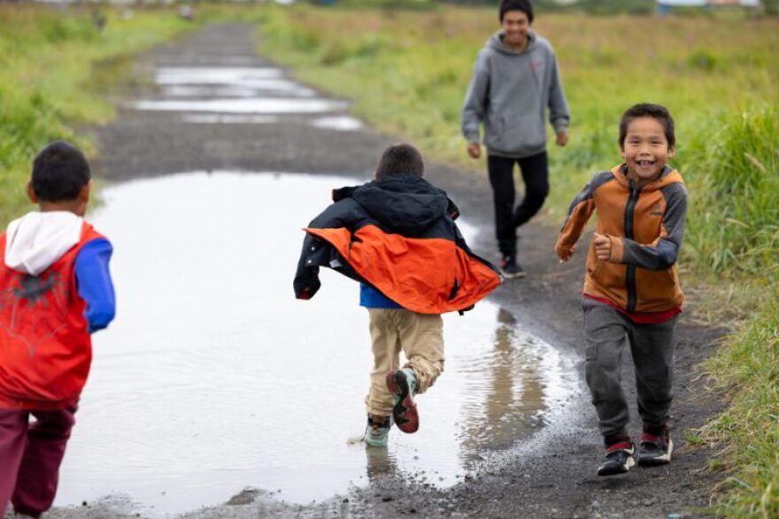 Gavin Pete, right, runs around a puddle in Stebbins.