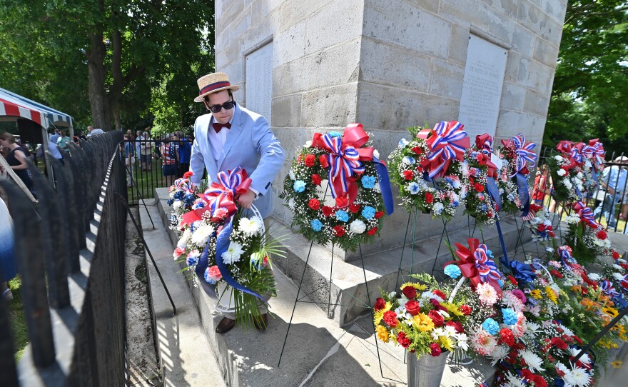 Willian Lewis places floral tributes from American Legion posts, Daughters of the American Revolution, and other descendants, societies and Luzerne County municipalities, at the base of Wyoming Monument.