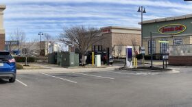  A Starbucks parking lot in a shopping center hosts an EV charging station. The lot is surrounded by a Jason's Deli and a Main Event store.