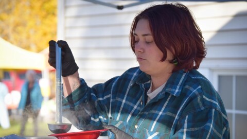 Bread Line administrator Emma DeRuyter ladles out free soup at the Southside Farmers Market in Fairbanks on Sept. 30, 2025, as part of the organization’s weekly community meal program. Many of the ingredients for the meals are donated by local farmers.