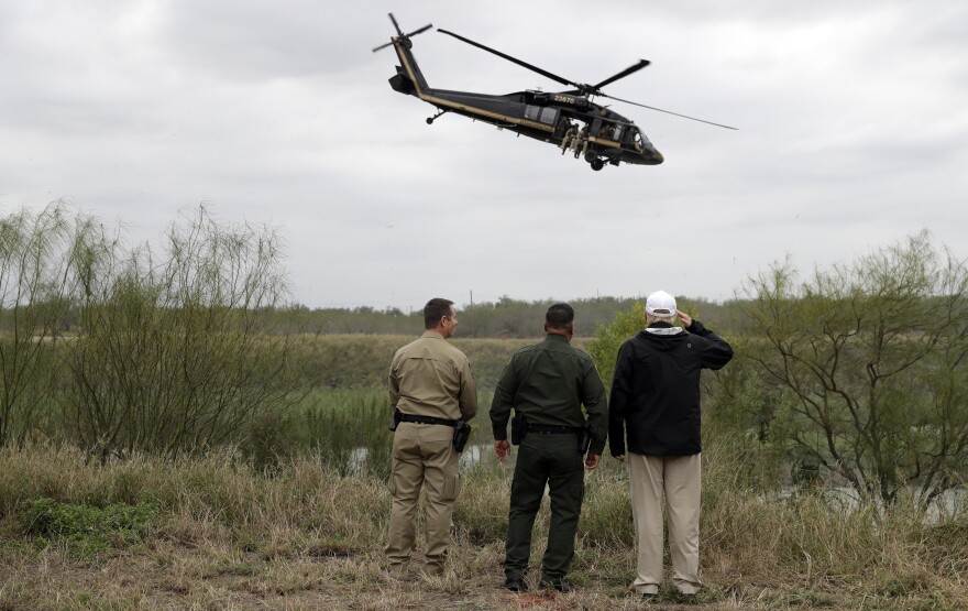 President Trump salutes a U.S. Customs and Border Protection helicopter as he tours the U.S. border with Mexico at the Rio Grande on Thursday in McAllen, Texas.