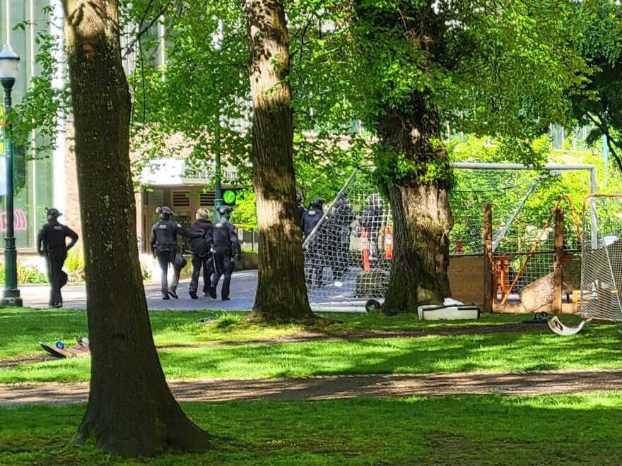 Portland police walk a suspected protester away from the Portland State University library on Thursday, May 2, 2024. Police converged on the PSU campus and library early in the morning to clear protesters who'd occupied the library since Monday night.