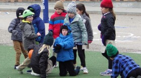 Children wearing coats, hats and gloves play with a ball Friday, Nov. 7, 2025, at St. Mary's Elementary School in Bismarck, N.D. (AP Photo/Jack Dura)