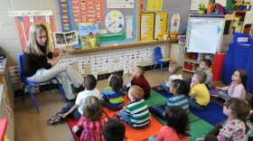 **ADVANCE FOR RELEASE SATURDAY, APRIL 2, 2011, AT 12:01 A.M. CDT** Angie Clark, a preschool teacher, reads to a group of four and five year old students, at Mitchell Elementary School, Tuesday March 29, 2011, in Des Moines, Iowa. (AP Photo/Steve Pope)