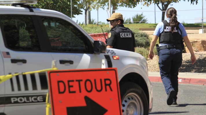 Authorities block access to an area on the University of New Mexico campus where two people were shot, one of them fatally, in the early morning hours in Albuquerque, N.M., on Friday, July 25, 2025. (AP Photo/Susan Montoya Bryan)
