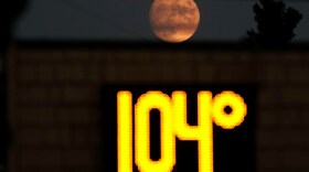 A temperature of 104 degrees is displayed on a digital thermometer as the moon rises over Sacramento, Calif., Thursday, Sept. 8, 2022. A heat wave setting several high temperature marks in California.