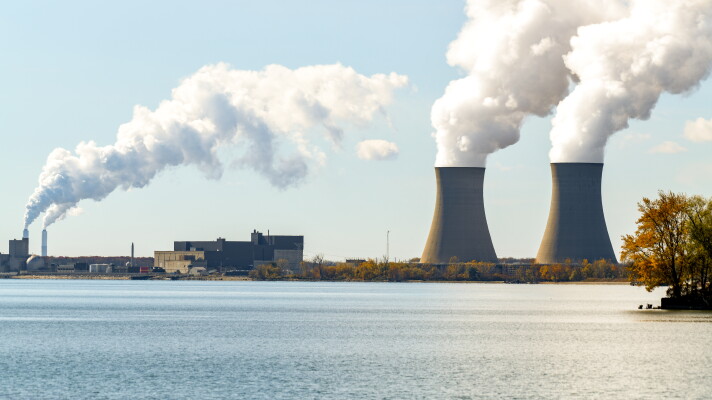 On the right, steam rises from the DTE Energy's Fermi 2 nuclear power plant. On the left in the distance the smoke stacks of the Monroe power plant. The USEPA's proposal would make such coal burning power plants capture 90 percent of greenhouse gas emissions.