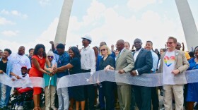 Attendees at Friday's "People's Ribbon Cutting" celebrate near the Gateway Arch grounds in St. Louis.