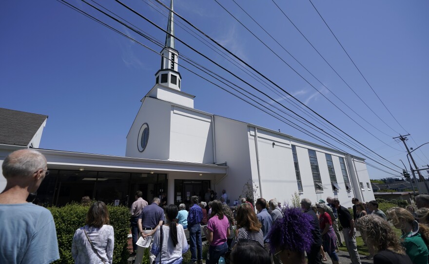 People gather Friday in the entryway of the United Churches of Olympia during a memorial service for Barnett Moss, who died outside the church during the heat wave. 