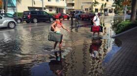 Oakley and Casey Jones, tourists from Idaho Falls, navigate the flooded streets of Miami Beach as they try to make their way to their hotel on Collins Avenue and 30th Street during a King Tide on Monday, Sept. 28, 2015.