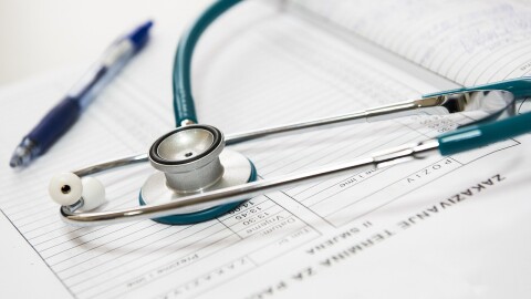 A stethoscope rests on a notebook of medical information.