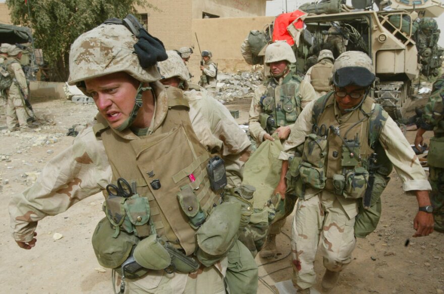 U.S. Marines of the 3rd batallion, 4th regiment, evacuate a dead comrade during fighting with Iraqi gunmen as they tried to secure a key bridge leading into Baghdad on the outskirts of the Iraqi capital, Monday, April 7, 2003. Four or five Marines were killed Monday when their Amtrack troop transporter was hit by an artillery shell at a bridge over a canal on the outskirts of the Iraqi capital.