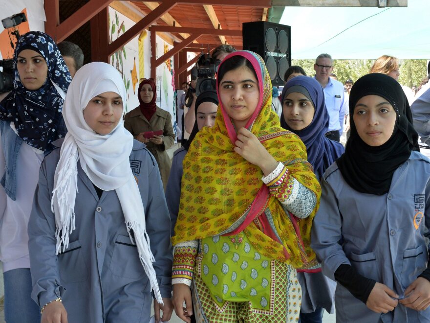 Malala Yousafzai walks with Syrian refugees on her 18th birthday, during the opening of a school for refugee girls in Lebanon's Bekaa Valley.