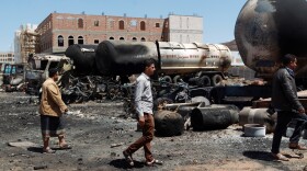 Yemenis walk past near oil tankers that were burnt during clashes between Shiite Houthi rebels and their opponents in the capital, Sanaa, in September. Saudi Arabia launched airstrikes this week to counter the Houthis' offensive.