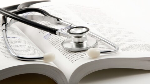 stethoscope on open book on a white background (Photo credit Dr. Farouk, CC BY 2.0, via Wikimedia Commons)
