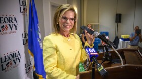 Republican U.S. Senate candidate Leora Levy holds her phone to a podium microphone to broadcast to supporters at her election night watch party a live congratulatory phone call from former president Donald Trump. Levy defeated Themis Klarides in tonight’s primary and will face incumbent U.S. Senator Richard Blumenthal.