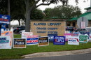 Campaign signs crowd the grass at the Alafaya Library parking lot in Orange County on Monday, Oct. 19, 2026. More voters cast ballots early in person at the library on Monday than at any other early voting location in Orange County.